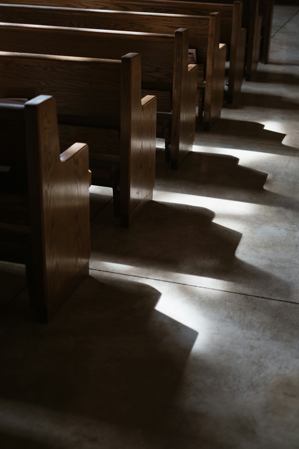 Puste drewniane ławki kościelne ciągnące się w dal.